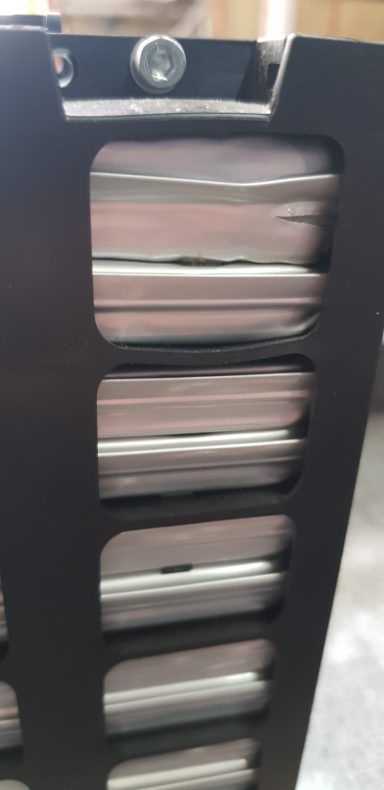 Schwarzer Aktenordner mit mehreren Papierstapeln und einer Kamera oben.